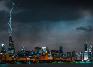 Nighttime photo of Chicago taken from Lake Michigan. Lightning is striking the top of the Sears Tower.